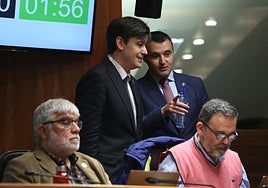El consejero de Hacienda, Guillermo Peláez, con una botella de agua, departe con su homólogo de Ciencia e Industria, Borja Sánchez, en un pleno de la Junta General.