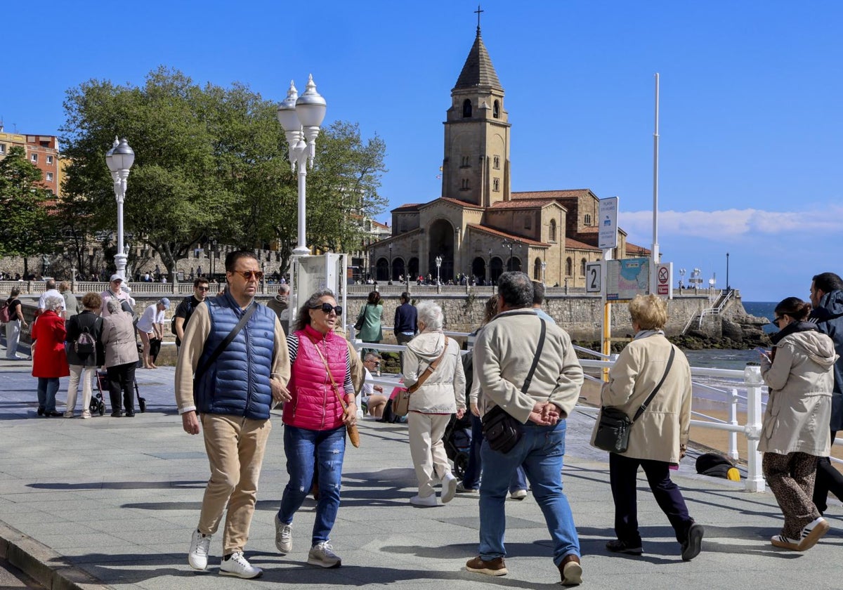 Turistas de paseo por el Muro de San Lorenzo, frente a la iglesia de San Pedro.