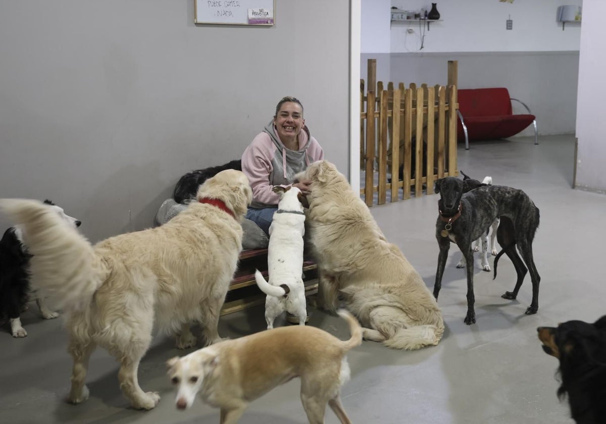 Patricia Granda posa con algunos de los usuarios de La Perroteca de la calle Prendes Pando, en Gijón.