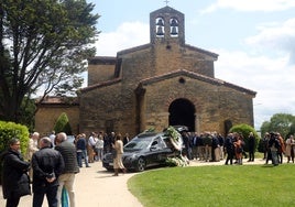 El coche fúnebre con los restos mortales de Luis Corzo, a la puerta de la iglesia prerrománica de San Julián de los Prados, a la una de esta tarde.