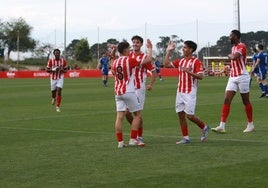 Los jugadores del Sporting Atlético celebran el gol de Manu, de espaldas.