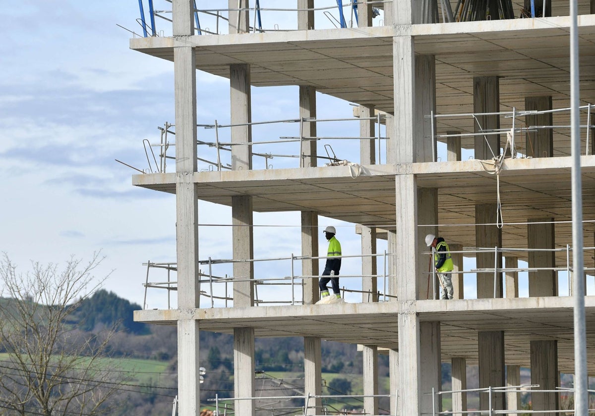 Dos operarios trabajan en la construcción de un edificio de viviendas.