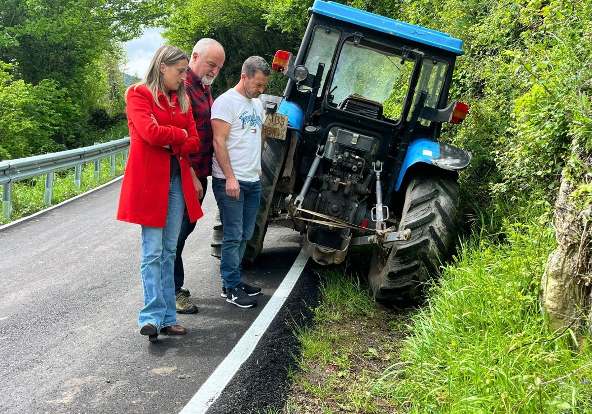 Cristina Vega observa la diferencia de altura entre la plataforma de la carretera y la cuneta no ejecutada. Un tractor queda inclinado, un coche podría volcar.
