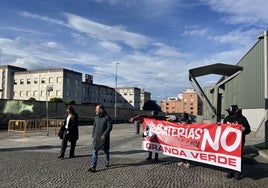 El alcalde de Siero, Ángel García, camina ante una pancarta de protesta vecinal.