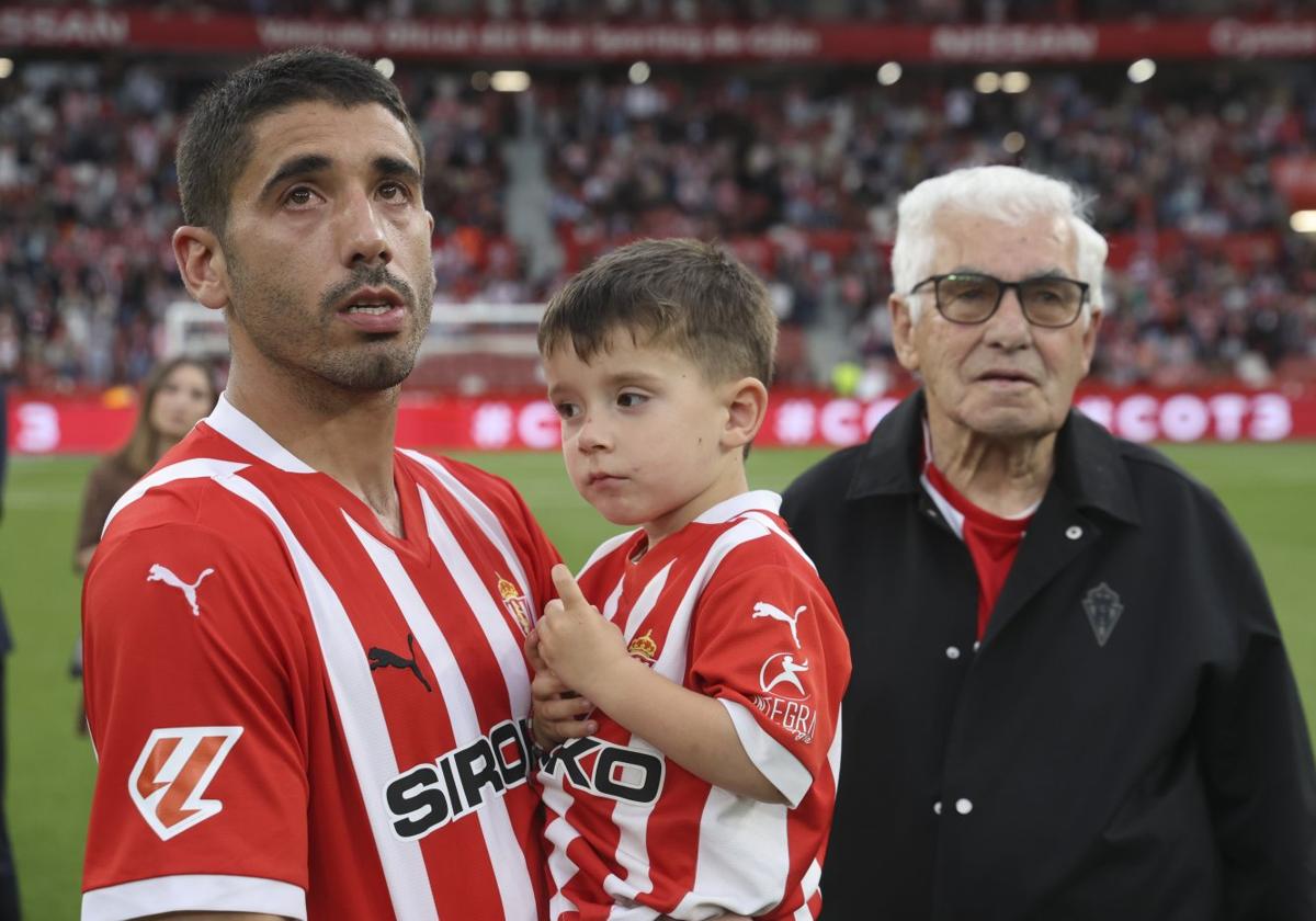 Cote, con su hijo Nel en brazos, observa las imágenes del videomarcador junto a su 'güelu' Pepe, al término del partido frente al Cartagena.