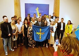 Adrián Barbón sujeta la bandera de Asturias rodeado de miembros del grupo Astur Explores y creadores de contenido digital.