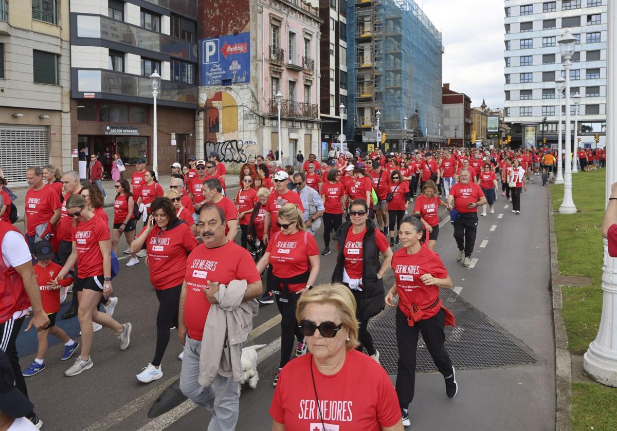 Marea de mil camisetas rojas en la marcha de Cruz Roja en Gijón