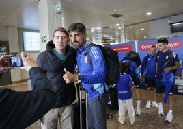 El técnico del Real Oviedo se fotografía, con el pulgar en alto, junto a un seguidor en el Aeropuerto de Asturias.