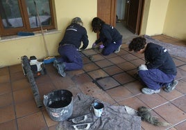 Trabajadores de un plan de empleo realizando labores de mejora en un equipamiento municipal.
