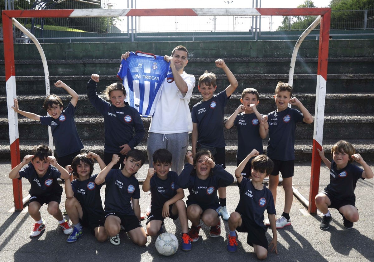 Pereira, ayer con una camiseta del Real Avilés de su época de jugador blanquiazul junto a los jugadores del equipo que entrena en el Colegio San Fernando.