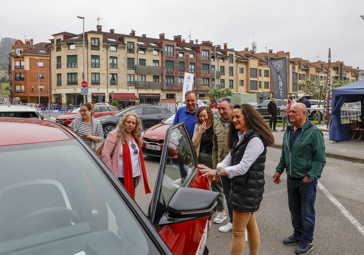 Autoridades municipales y de la organización observan uno de los coches a la venta