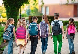 Un grupo de niños y niñas, de camino al colegio.