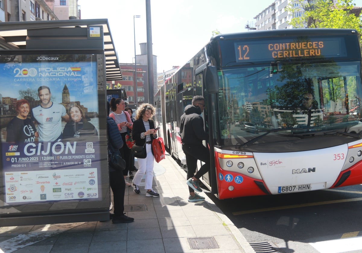 Usuarios de EMTUSA en la Acerona, en la parada de la Gota de Leche, subiéndose a un autobús de la línea 12.