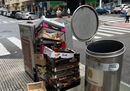 Restos de cajas de los comercios apilados junto a los cubos de basura en pleno centro urbano de Pola de Siero.