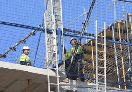 Trabajadores en la construcción de un edificio de viviendas en Gijón.