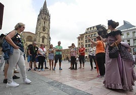 Un grupo de turistas escucha las explicaciones de la guía de turismo en la plaza de la Catedral de Oviedo.