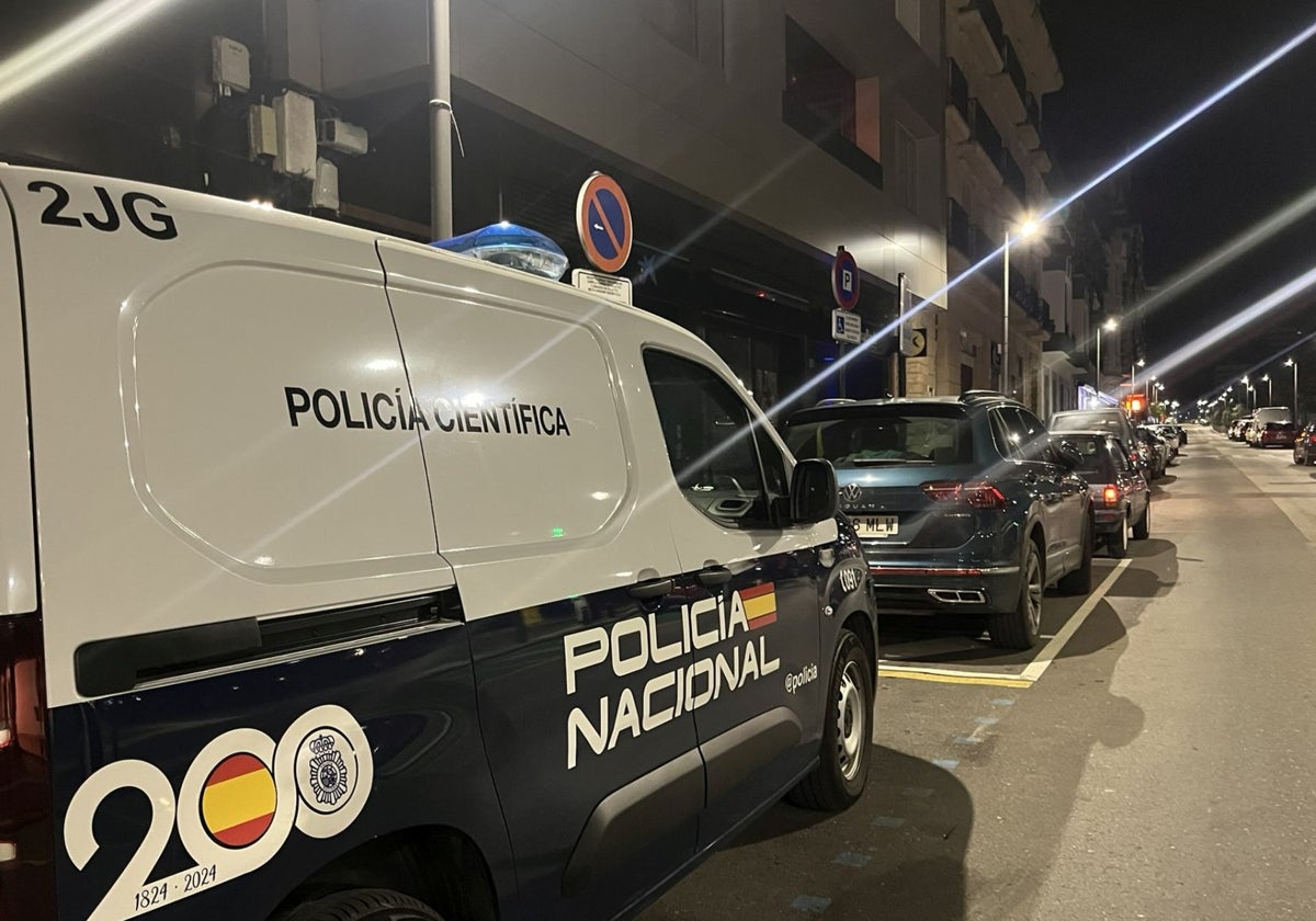 El vehículo de la Policía Científica, cerca del portal donde ocurrió el suceso el pasado jueves.