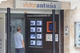 Un hombre mira la oferta de vivienda que se encuentra en el exterior de la inmobiliaria Víctor Antuña.