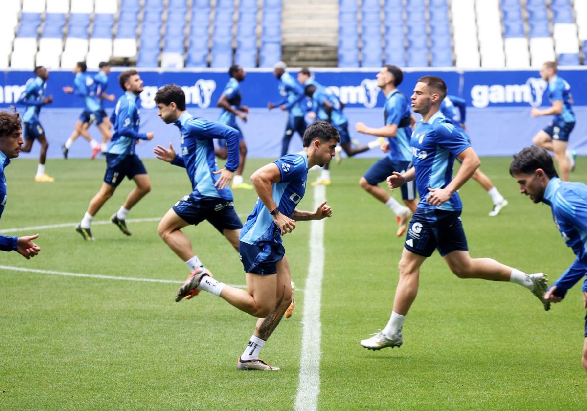 Los jugadores del Real Oviedo realizan un ejercicio de calentamiento durante el entrenamiento de ayer en El Requexón.