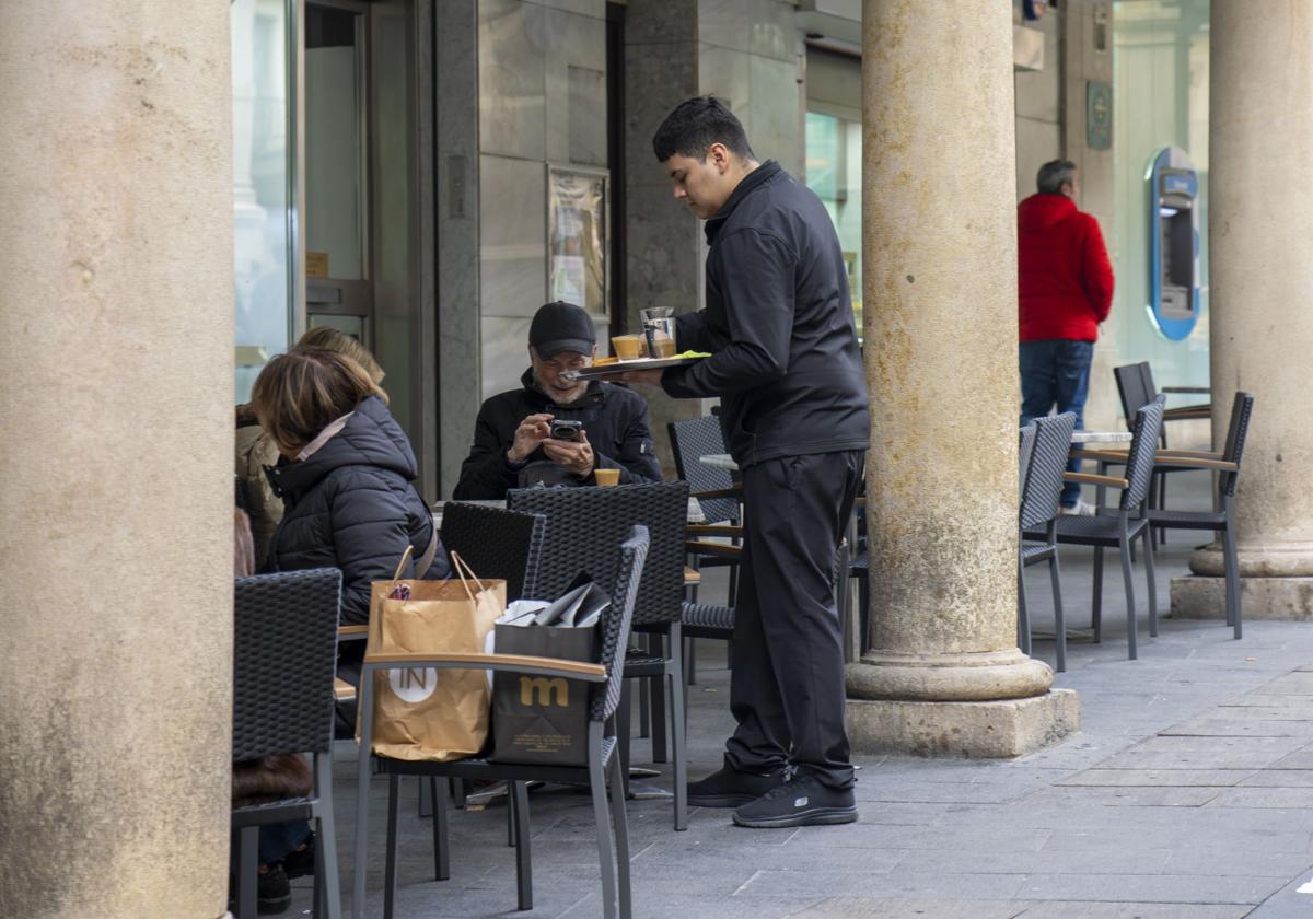Un camarero atiende una terraza.