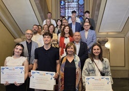 Ana Fernández de la Corte, Marco Suárez Menéndez y Lara Iglesias, junto a la alcaldesa. Detrás, el concejal de Educación, el presidente del Rotary, familiares y profesores.