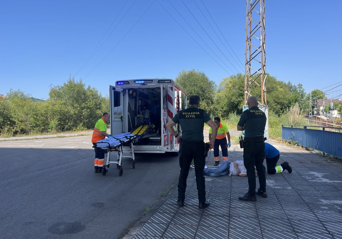 El herido, en el suelo, mientras es atendido por los servicios sanitarios bajo el puente en Meres.