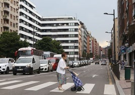 Una mujer cruza un paso de cebra en General Elorza, bajo las nuevas farolas instaladas.