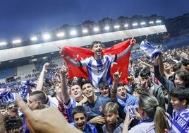 Un grupo de aficionados celebra con Nico Fernández el ascenso del Real Avilés sobre el césped del Suárez Puerta.