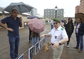 Un veterano de los COE 72 explica a un vecino de El Coto la exposición de fotografías durante el acto por el 125 aniversario del acuartelamiento en la plaza de La República organizada por la asociación vecinal.