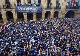 Una familia espera en Oviedo la llegada del autobús con los jugadores.