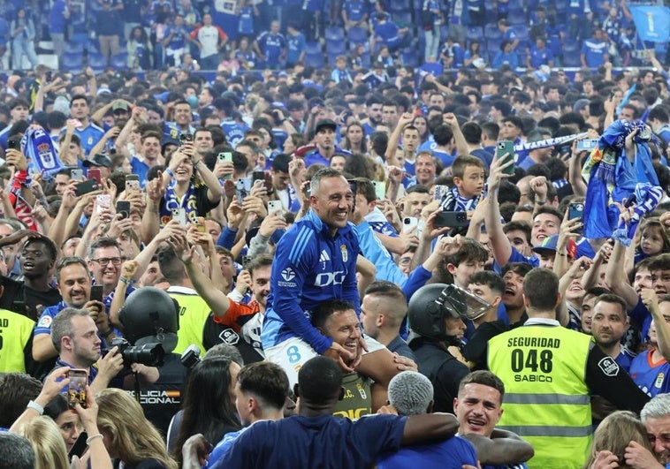 Cazorla, a hombros rodeado de la afición del Real Oviedo, que tomó el campo del Tartiere.