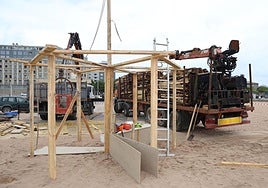 Operarios del Ayuntamiento de Gijón montan la hoguera de San Xuan de este año.