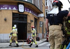 Los bomberos en el bar El Quinto extinguen el humo y el fuego