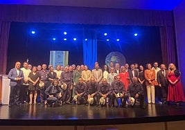 Los galardonados, en el centro, rodeados de autoridades, patronos y el Coro Minero de Turón tras cantar el 'Asturias patria querida'.