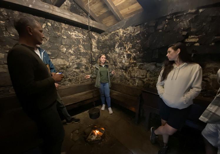 María Rey, ganadera, música y guía del Museo de los Teitos de Veigas (Somiedo), junto al llar de uno de los teitos de este museo somedano, mientras da explicaciones a los turistas. Toda una exhibición de diversificación laboral en el entorno rural.