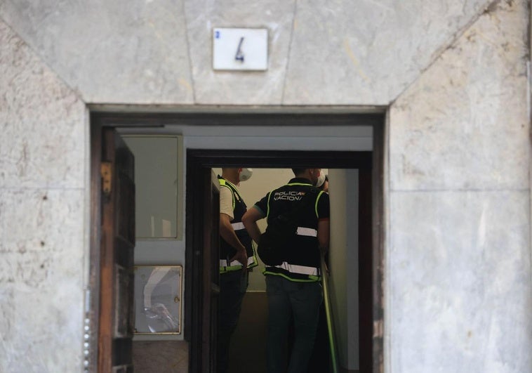 Investigadores acceden al piso donde fue hallado el cadáver de una mujer dentro de un cubo de basura, en la calle Contracay de Gijón.