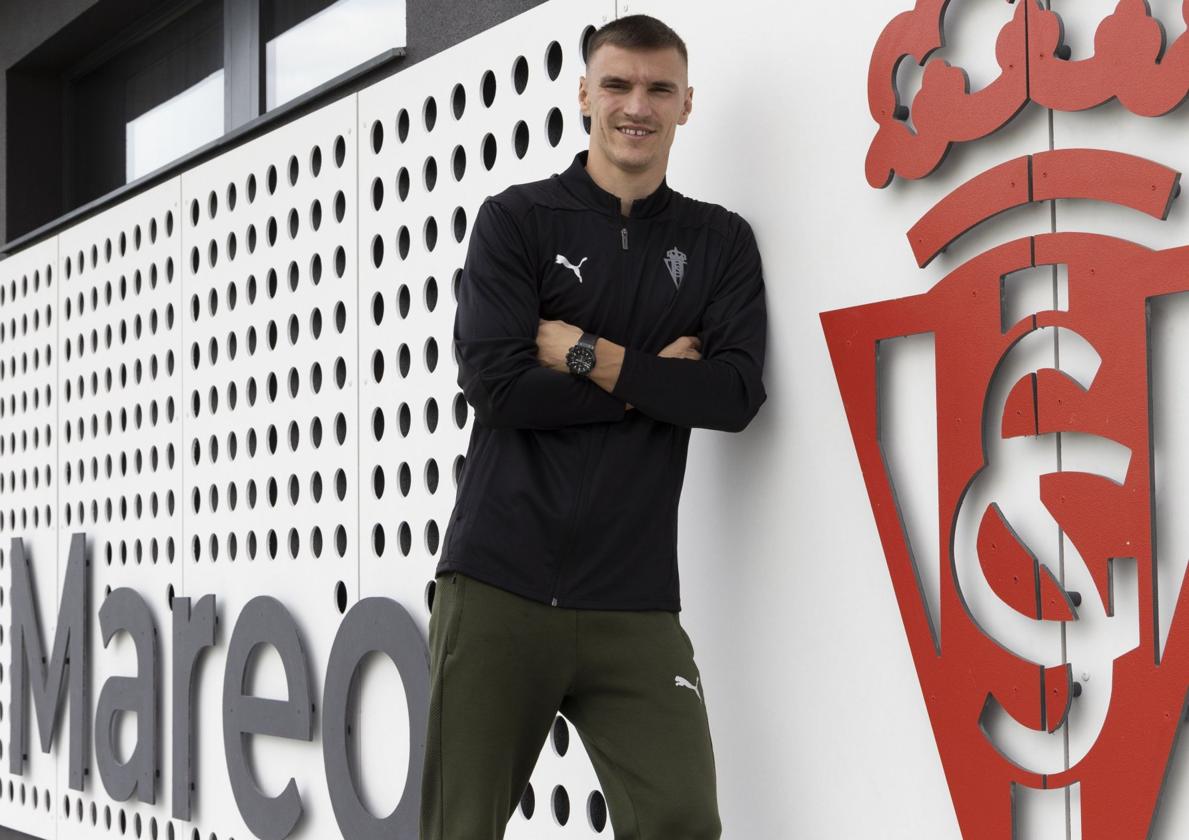 Niko Maras, el curso pasado, posando junto al escudo del Sporting de Gijón en Mareo.