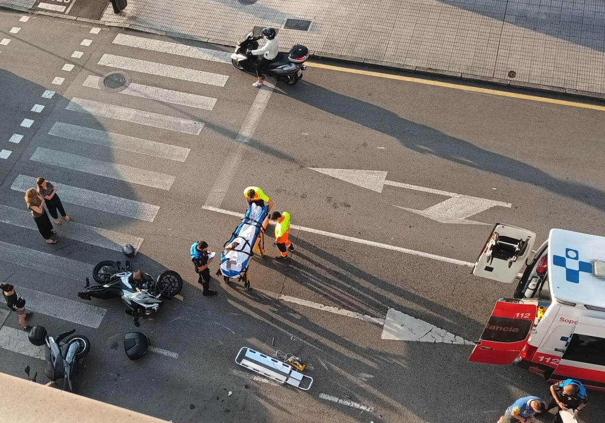 Los sanitarios trasladan en camilla al motorista herido mientras los agentes de la Policía Local recaban información.