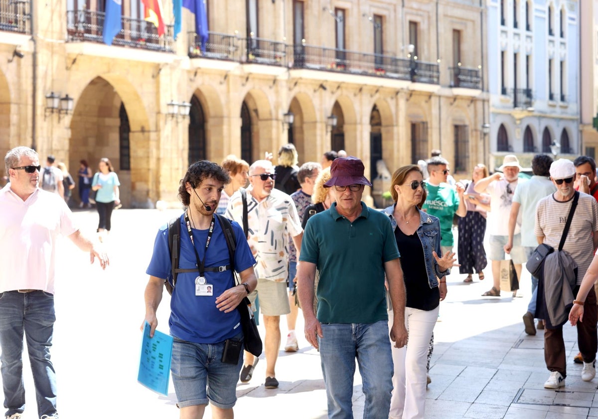 Un guía acompaña de un grupo de turistas en la plaza de la Constitución este viernes.