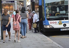 Viajeros subiendo y bajando de un autobús de la Compañía del Tranvía de Avilés en Las Meanas.