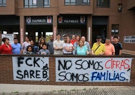 Los vecinos del bloque de la calle Río Piloña, en Contrueces, este martes con pancartas de protesta.