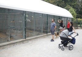 Visitantes ante la pajarera del parque Isabel la Católica.