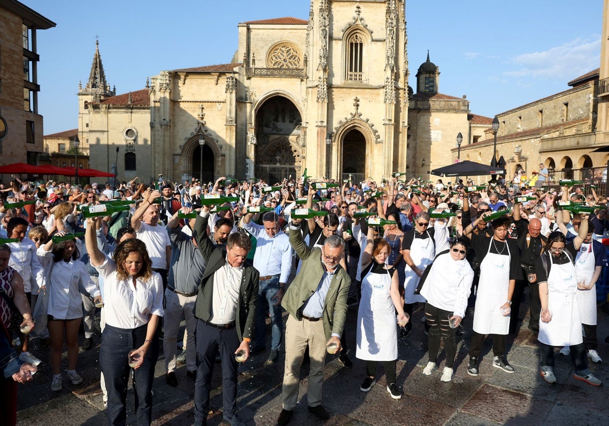 Cientos de persona alzan sus botellas de sidra para realizar el gran escanciado simultáneo en la plaza de la Catedral.