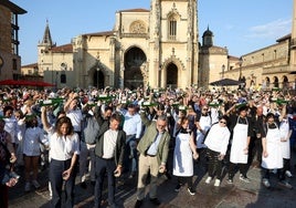 Cientos de persona alzan sus botellas de sidra para realizar el gran escanciado simultáneo en la plaza de la Catedral.