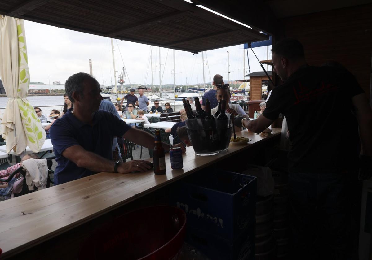 Uno de los puestos gastronómicos con gente sentada en las mesas detrás.