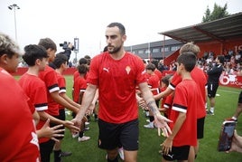 Los jugadores del Sporting de Gijón llegan al campo de entrenamiento atravesando el pasillo de los niños del campus con Perrin en primer término.