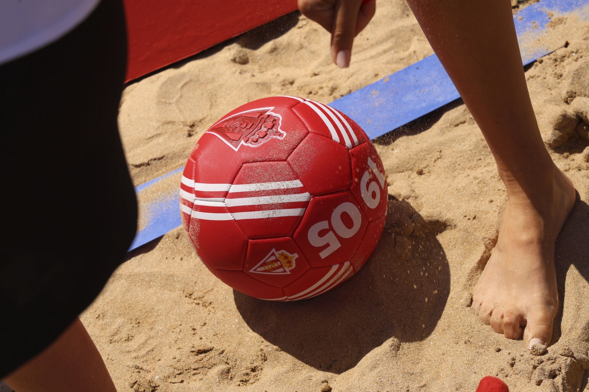 El Sporting de Gijón presenta su nueva equipación con una pachanga en la playa