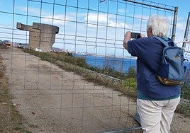 Una turista fotografía el Elogio del Horizonte a través del vallado que impide acercarse a él desde principios de mayo.