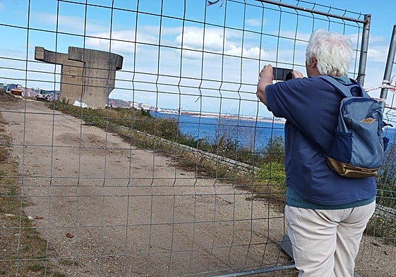 Una turista fotografía el Elogio del Horizonte a través del vallado que impide acercarse a él desde principios de mayo.