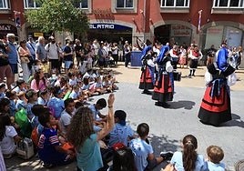 Un grupo de menores que disfrutaba ayer de Avilés se sentó en el suelo para escuchar a Esbardu.